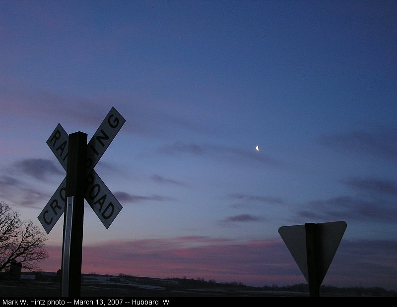 sunrise over railroad crossing signs