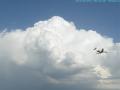 big puffy white cloud, and an airplane